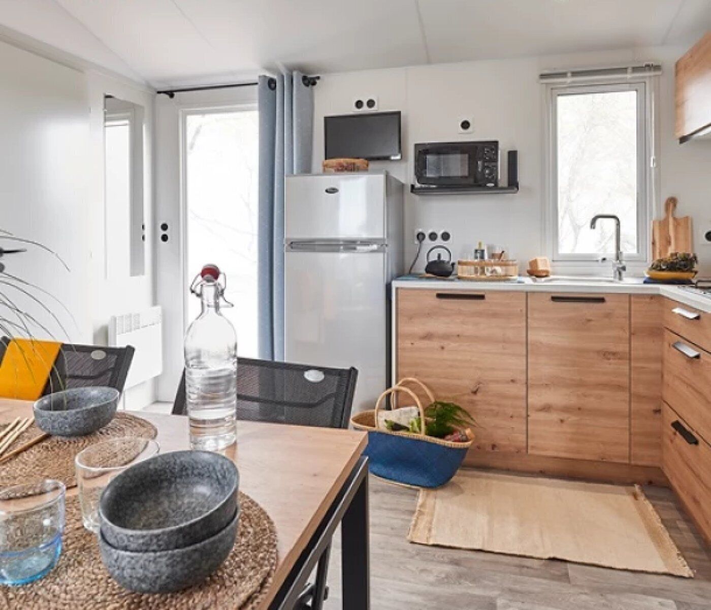 Una cocina compacta con microondas, refrigerador y armarios de madera.