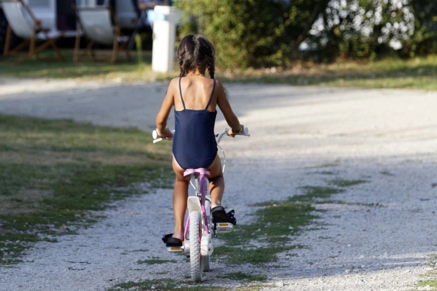 Eine Person fährt Fahrrad auf einem Schotterweg.