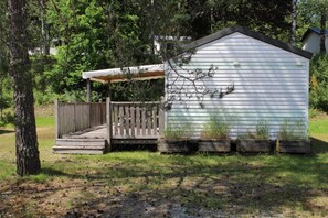 Escape to a secluded cabin surrounded by nature, with a deck and covered porch.