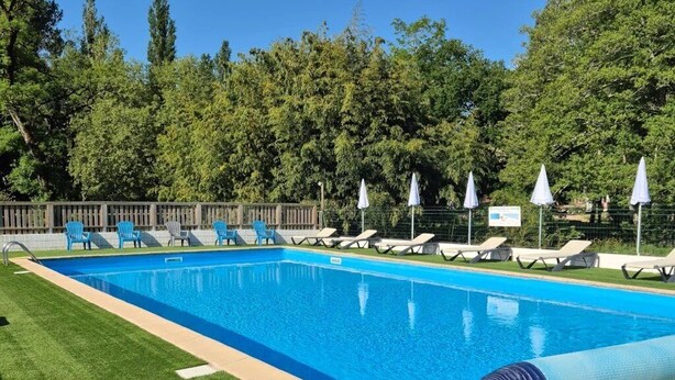 Piscina rectangular con plataforma de madera y sistema de filtración de agua.