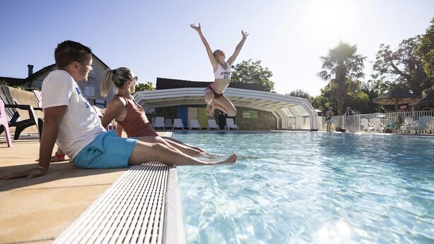 A poolside area with a clear sky, a pool, and a covered seating area. - ZEcamping 4 étoiles familial animaux acceptés terrain multisports (Thégra)