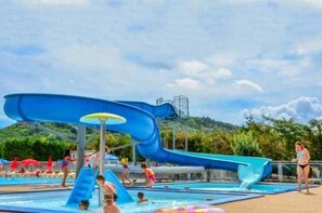 Guests can enjoy a refreshing swim in the pool surrounded by lush greenery.