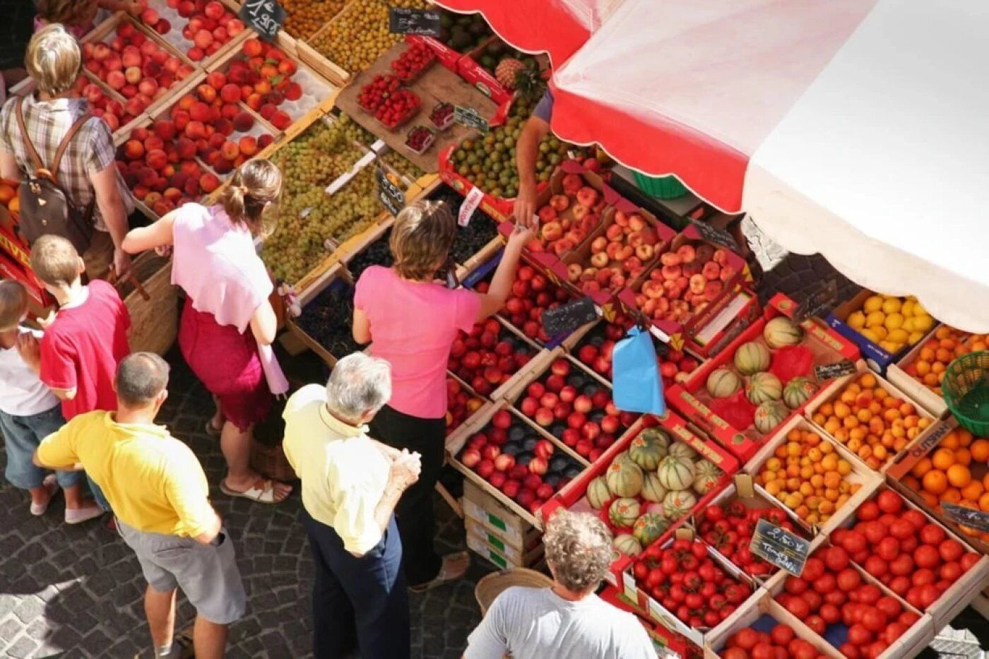 A fruit market with various fruits displayed in wooden crates.