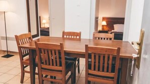Un área de comedor con una mesa y sillas de madera, una lámpara de pie y un espejo en la pared.
