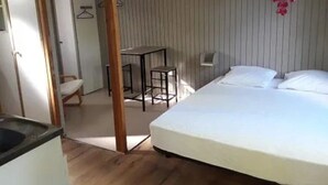 A bedroom with a bed, a desk, and a chair.