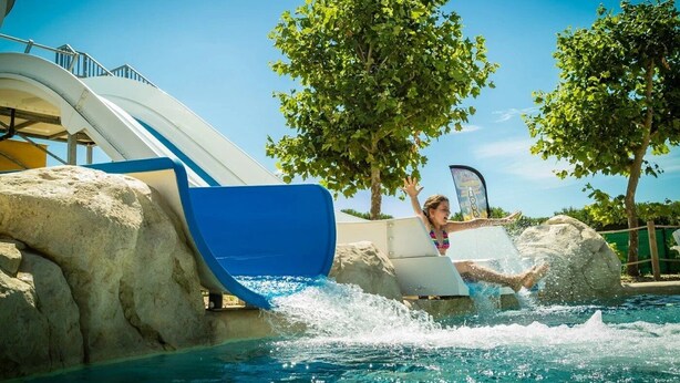 Tobogán de agua en un parque acuático con una persona deslizándose.