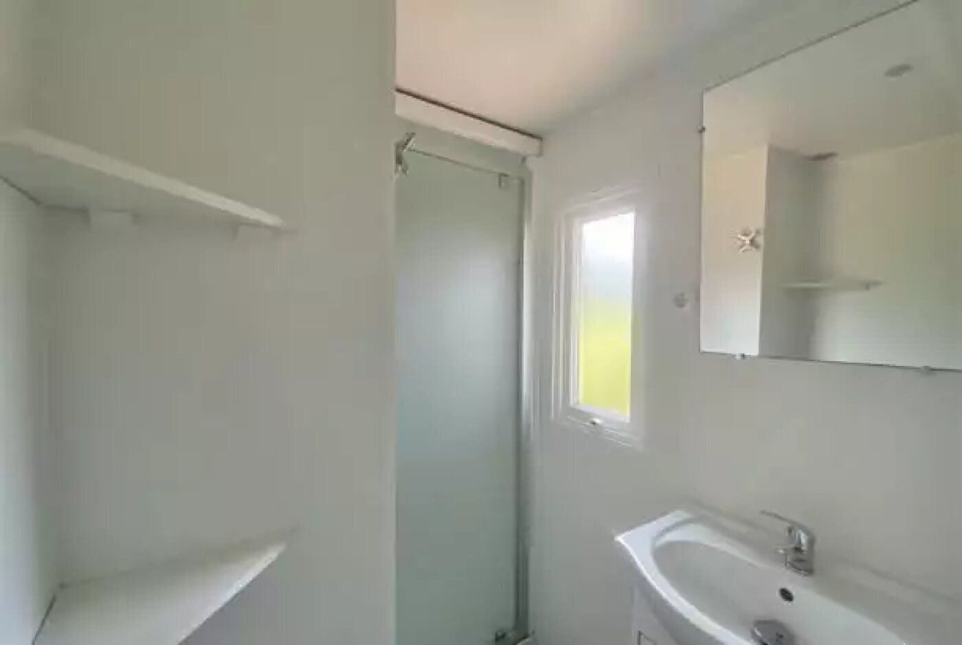 A bathroom with a shower, a sink, and a mirror.