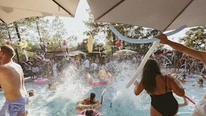 Ein Poolbereich mit aufblasbaren Spielzeugen und Menschen, die das Wasser genießen.