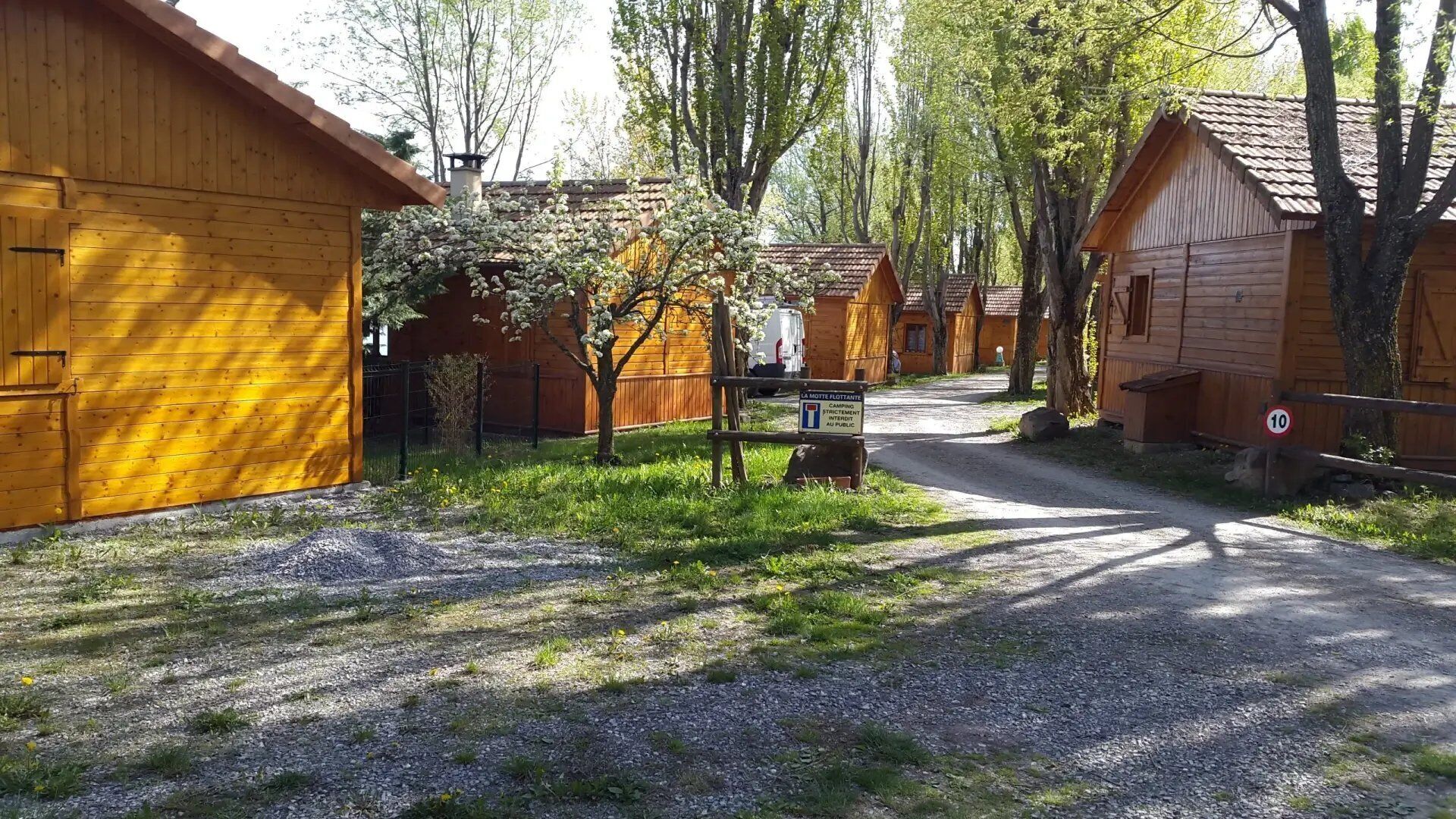 Eine Reihe von Holzhütten mit einem Kiesweg, der hindurchführt.