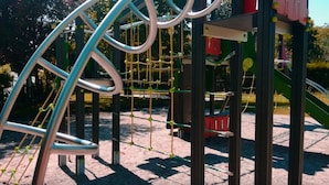 Ein Spielplatz mit einer Kletterkonstruktion und einer Rutsche.