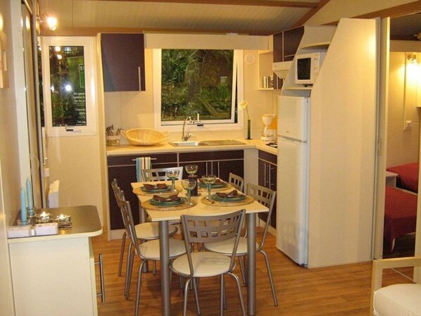 A compact kitchen with a dining area, a sink, and a microwave.