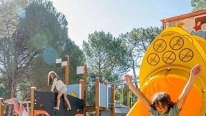 A playground with a yellow slide and climbing structures.