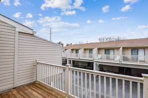 A residential building with a wooden deck and balconies.