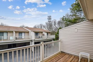 A two-story mobile home with a balcony and a small deck area. - Cozy Sea Pines Getaway! Features Community Pool and Short Walk to The Beach. (Bethany Beach)
