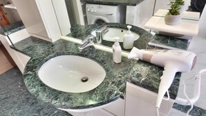 Ein Badezimmer mit Waschbecken, Spiegel und Föhn.