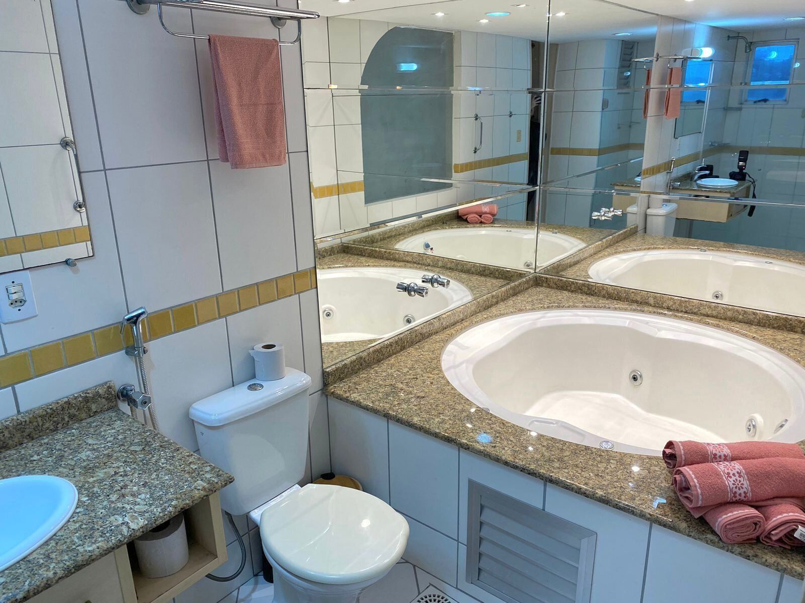 A modern bathroom with a large freestanding bathtub, a double sink vanity, and a toilet.