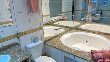 Un baño moderno con una bañera independiente grande, un tocador con doble lavabo y un inodoro.