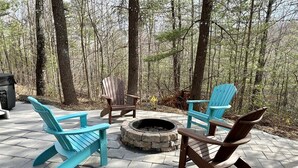 A fire pit surrounded by Adirondack chairs on a paved patio. - Cabin #1 - Fantasy Hideaway (Stanardsville)