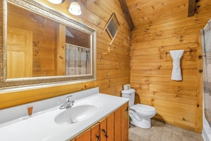 A wooden cabin bathroom with a sink, mirror, toilet, and towel rack. - Cabin #6 - Laurel Haven (Stanardsville)