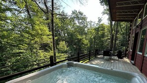 A hot tub on a wooden deck with a view of a forest. - Second Wind Mountain Cabin (Stanardsville)