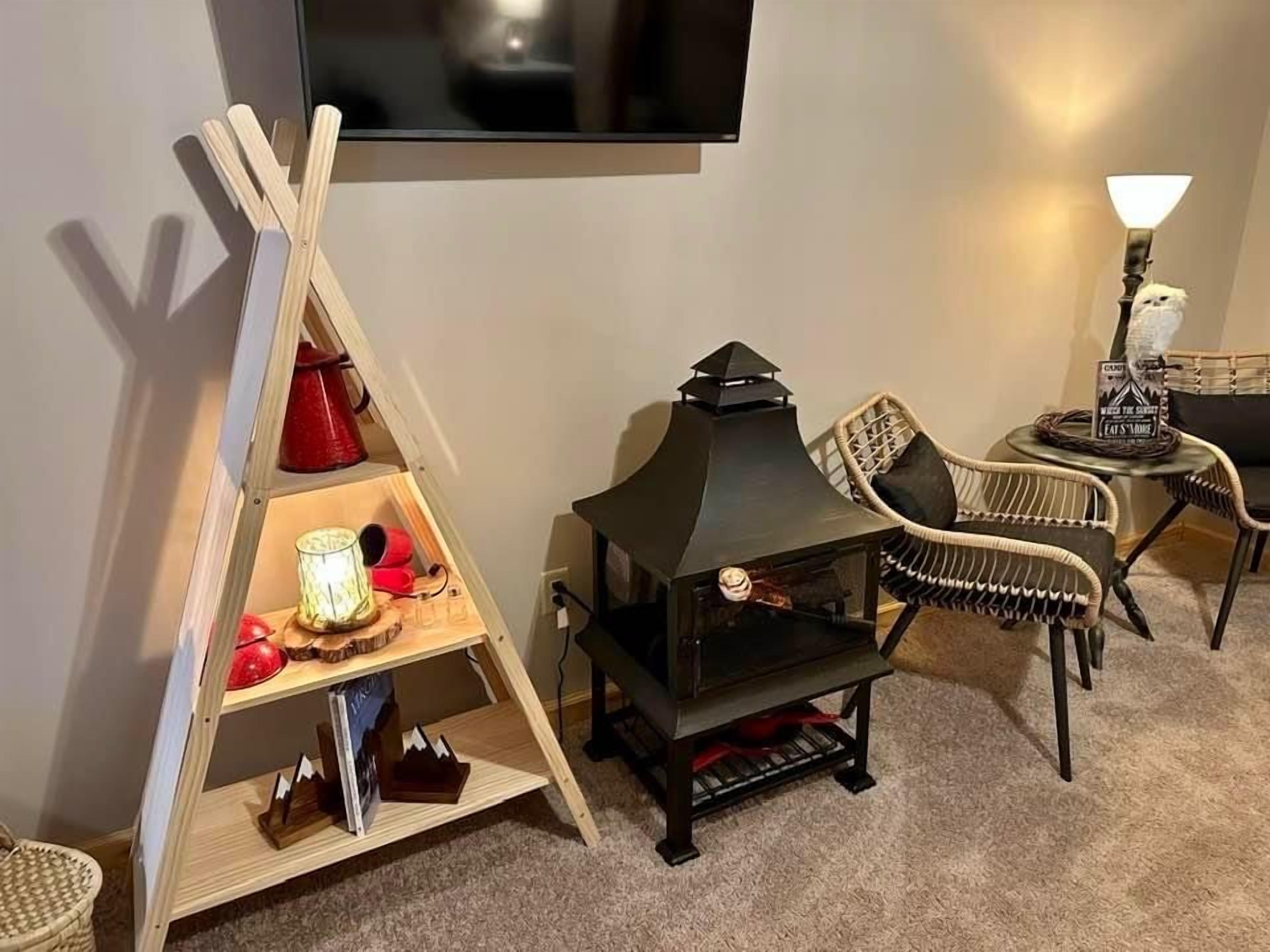 A cozy living area with a fireplace, a television mounted on the wall, and a comfortable chair.