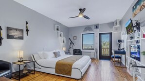 A modern bedroom with a bed, bedside tables, a desk, and a bookshelf. - Lodge Room 110 - The Zen (Stanardsville)