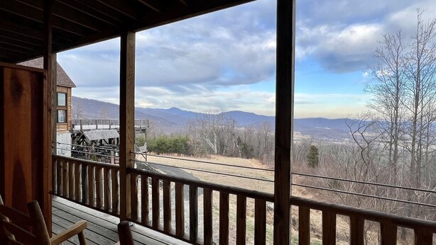 A wooden deck with a view of mountains and a train track. - Lodge Room 110 - The Zen (Stanardsville)