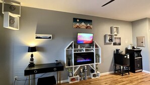 A modern room with a TV, desk, shelves, and a coffee machine. - Lodge Room 110 - The Zen (Stanardsville)