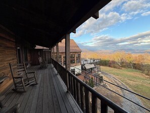 A wooden cabin with a porch, a view of a mountain range, and a clear sky. - Presidential Suite - Rm. 205 (Stanardsville)