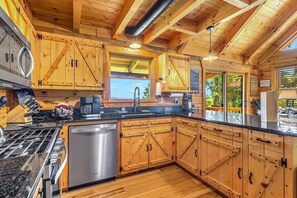 A kitchen with wooden cabinets, a stainless steel dishwasher, and a granite countertop.