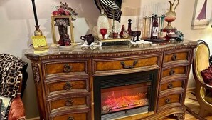 Un meuble en bois doté d’une cheminée, de tiroirs et d’objets décoratifs.