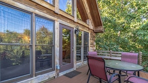 A wooden deck with a table and chairs, large windows, and a wooden fence. - Cabin #10 - Our Mountain Cabin (Stanardsville)