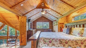 A wooden cabin with a loft bedroom, a desk, and a rocking chair. - Cabin #10 - Our Mountain Cabin (Stanardsville)