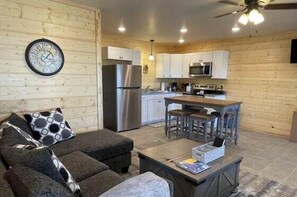A modern log cabin interior with a living room, kitchen, and dining area. - Speckled Owl Mountain Cabin (Stanardsville)