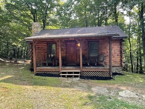 A log cabin with a porch, a chimney, and a door. - Cabin #2 - Granny B`s (Stanardsville)
