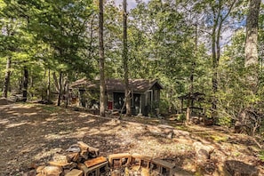 A rustic cabin surrounded by dense forest. - Bear Paw Mountain Cottage (Stanardsville)