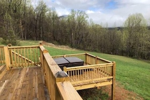 A wooden deck with a bench and a suitcase.