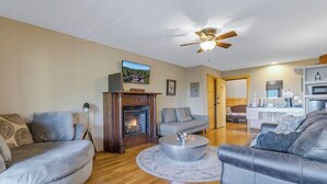 A living room with a fireplace, sofas, a coffee table, and a ceiling fan. - Hollywood Suite - Rm. 204 (Stanardsville)