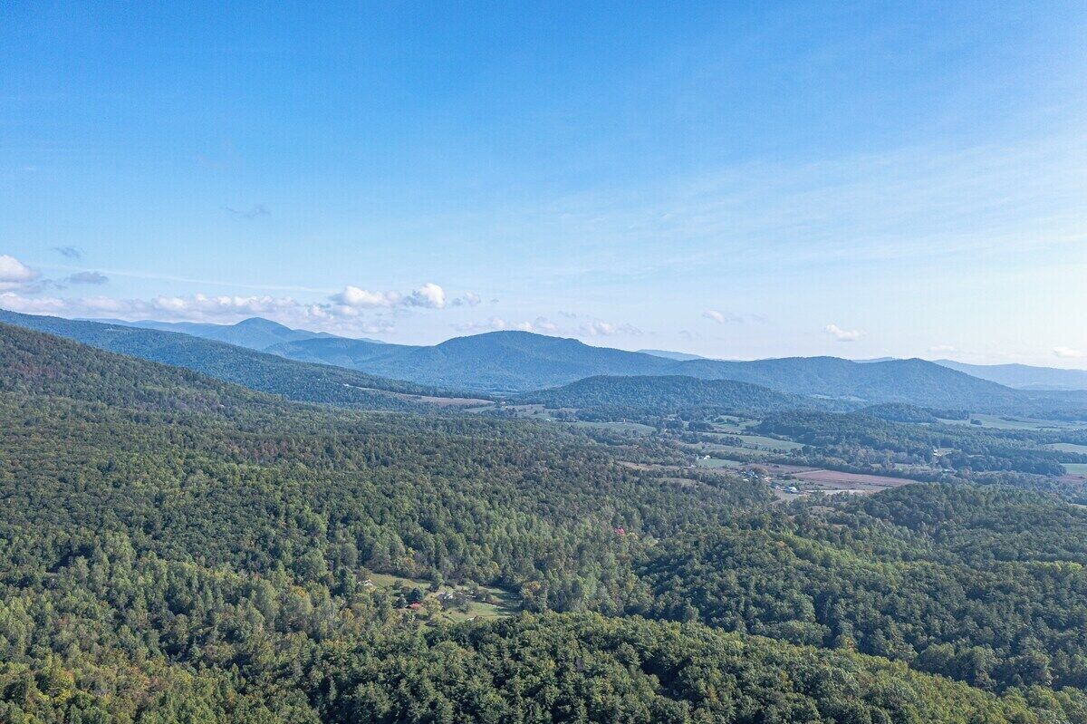 A mountainous landscape with dense forests and a clear sky.