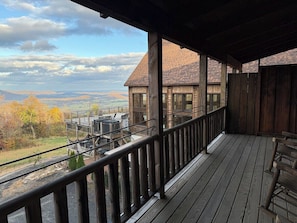 A wooden deck with a view of a mountain landscape.