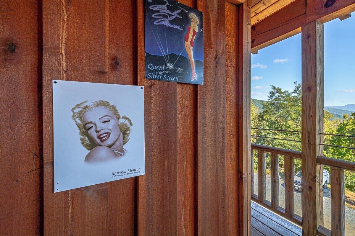 Une cabane en bois ornée d’une affiche de Marilyn Monroe et d’une autre représentant une femme en maillot de bain.