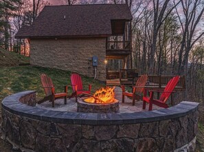 A stone building with a fire pit and red Adirondack chairs. - Mountain Mist Mountain Cabin (Stanardsville)