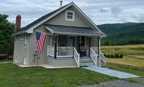 A single-story house with a porch, a chimney, and an American flag. - Mountain View Farmhouse (Stanardsville)