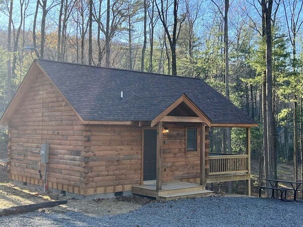 A log cabin with a porch and a small deck, surrounded by trees. - Almost Heaven Mountain Cabin (Stanardsville)