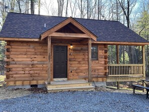 A wooden cabin with a front door, a porch, and a bench. - Almost Heaven Mountain Cabin (Stanardsville)