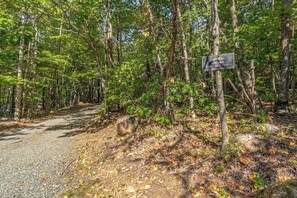 A forested area with a gravel path and a sign that reads 'LOVE NEST No. 3'.