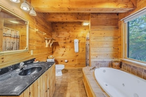 A wooden cabin bathroom with a sink, toilet, bathtub, and a large mirror. - Cabin #3 - Honey Pot (Stanardsville)