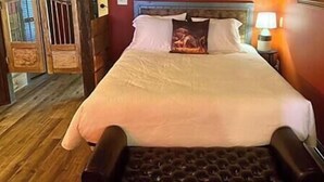 Ein Bett mit Kopfteil, einer Nachttischlampe und Holzboden.