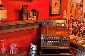 A bar area with a jukebox, glasses, and a bottle of liquor.