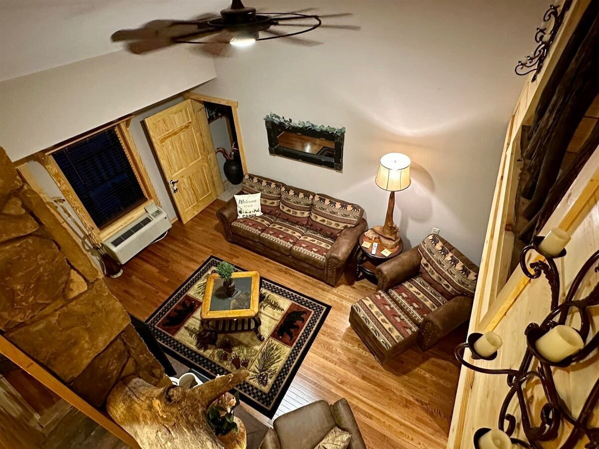 A living room with a sofa, armchairs, a coffee table, a lamp, and a ceiling fan.